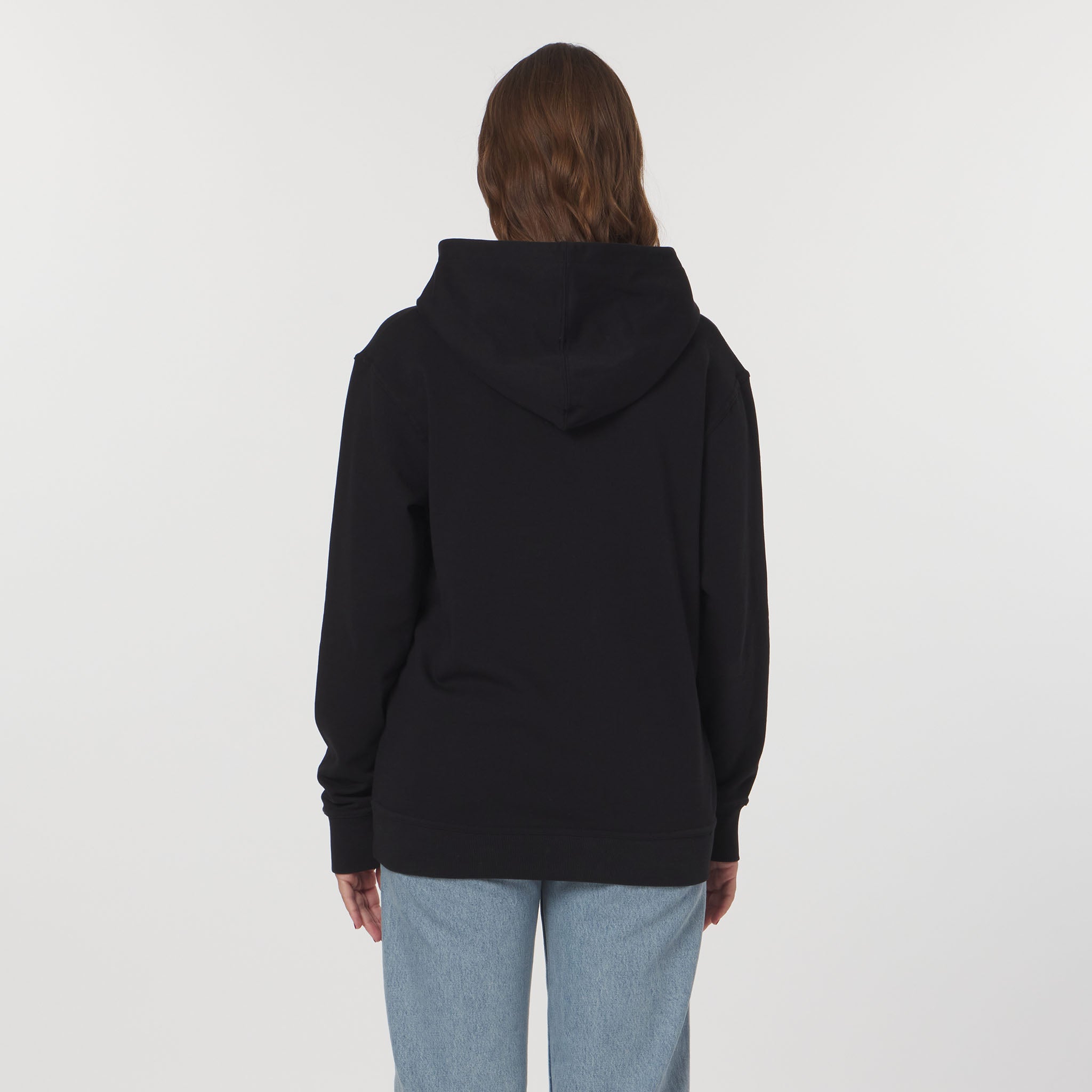Person wearing a black hoodie from behind on a light gray background