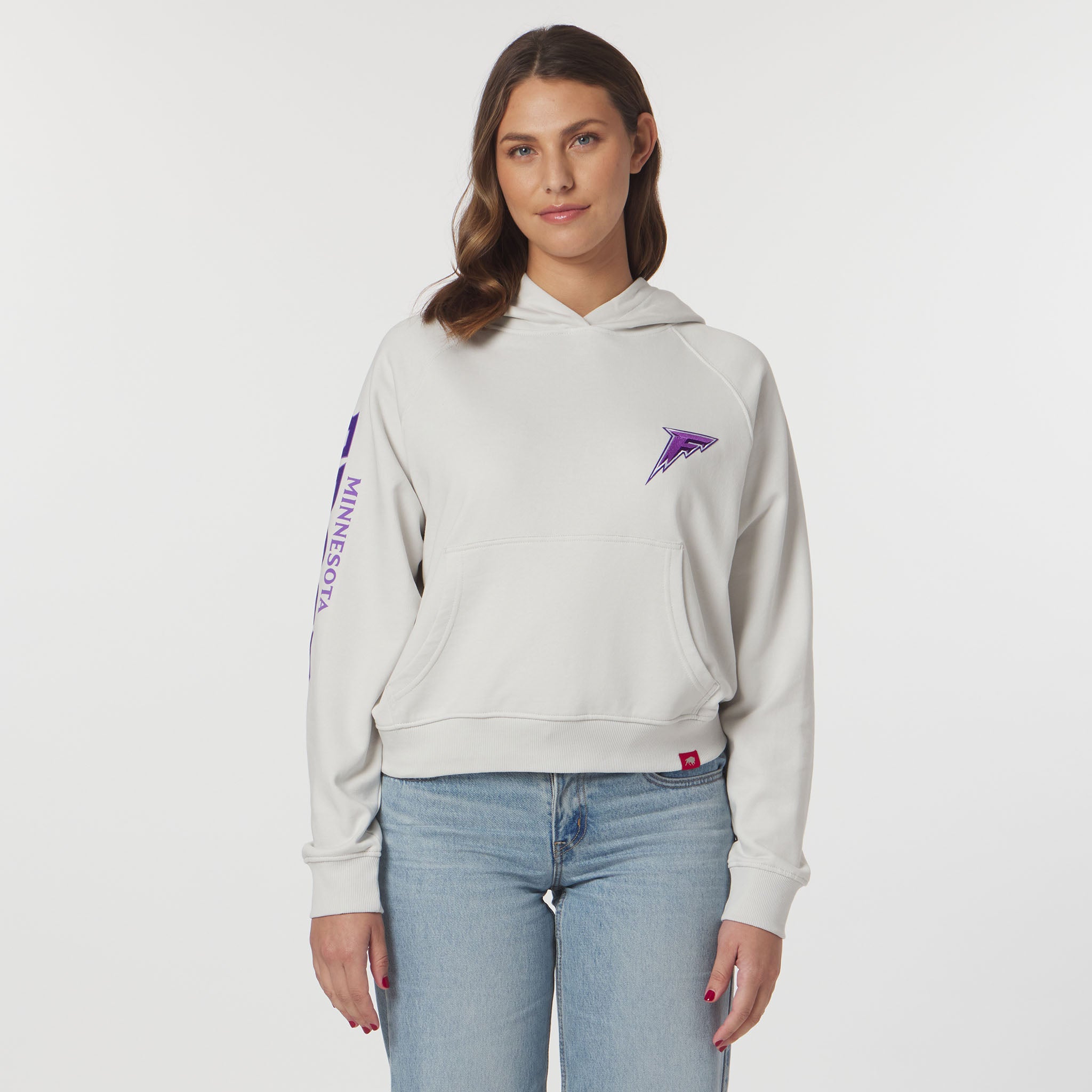 Woman wearing a light gray hoodie with purple accents on a white background