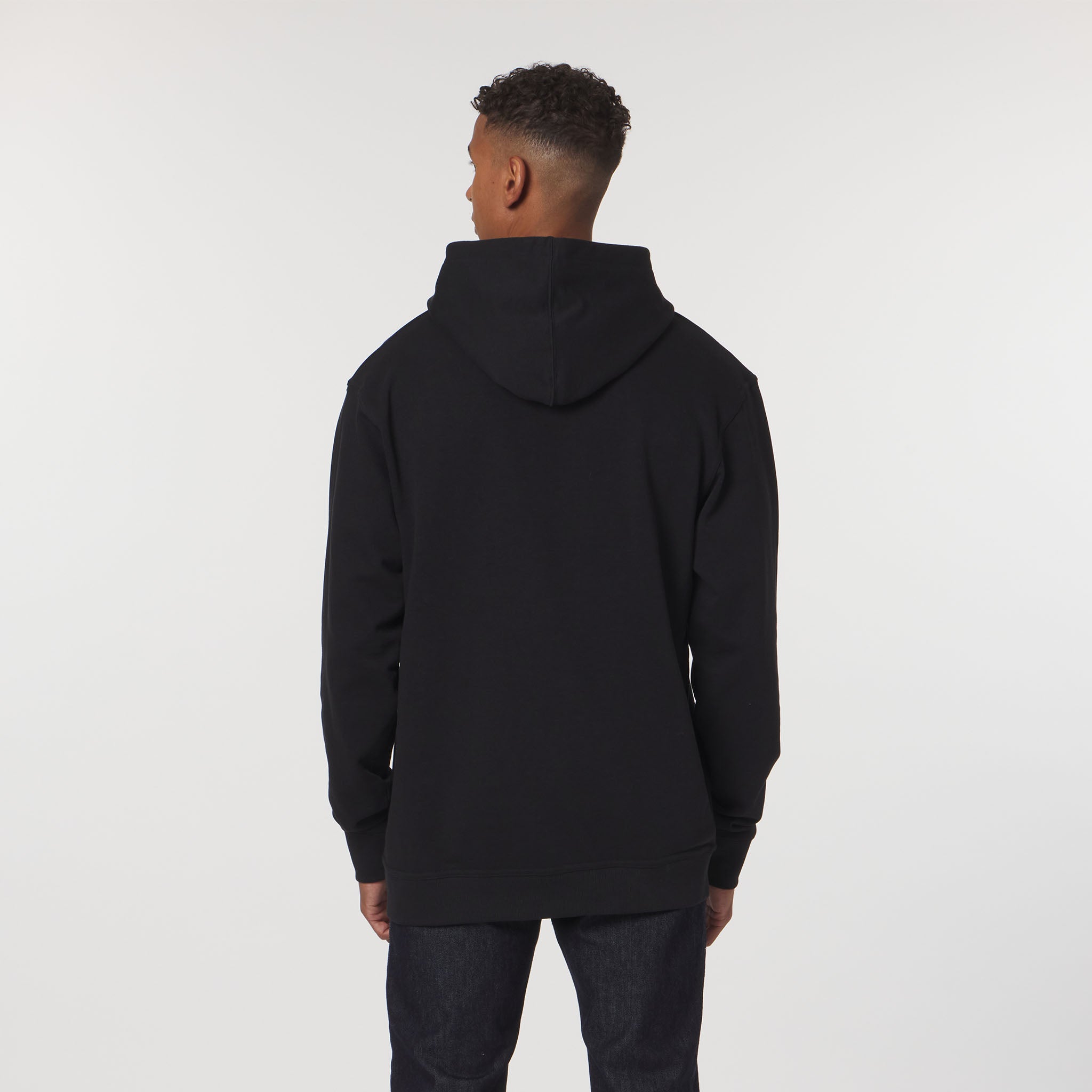 Person wearing a black hoodie from behind on a white background
