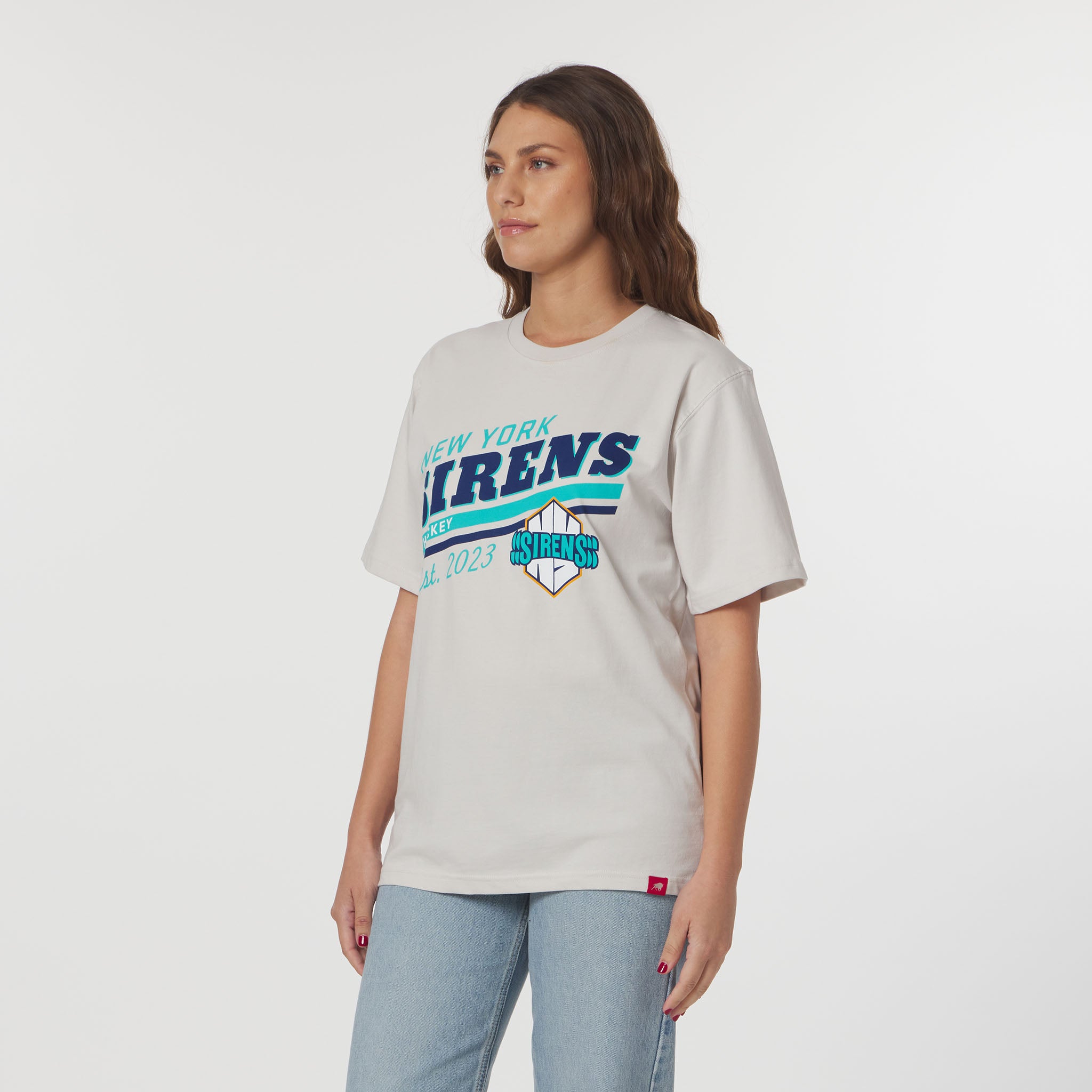 Woman wearing a white t-shirt with 'New York Firens' text and graphics on a plain background