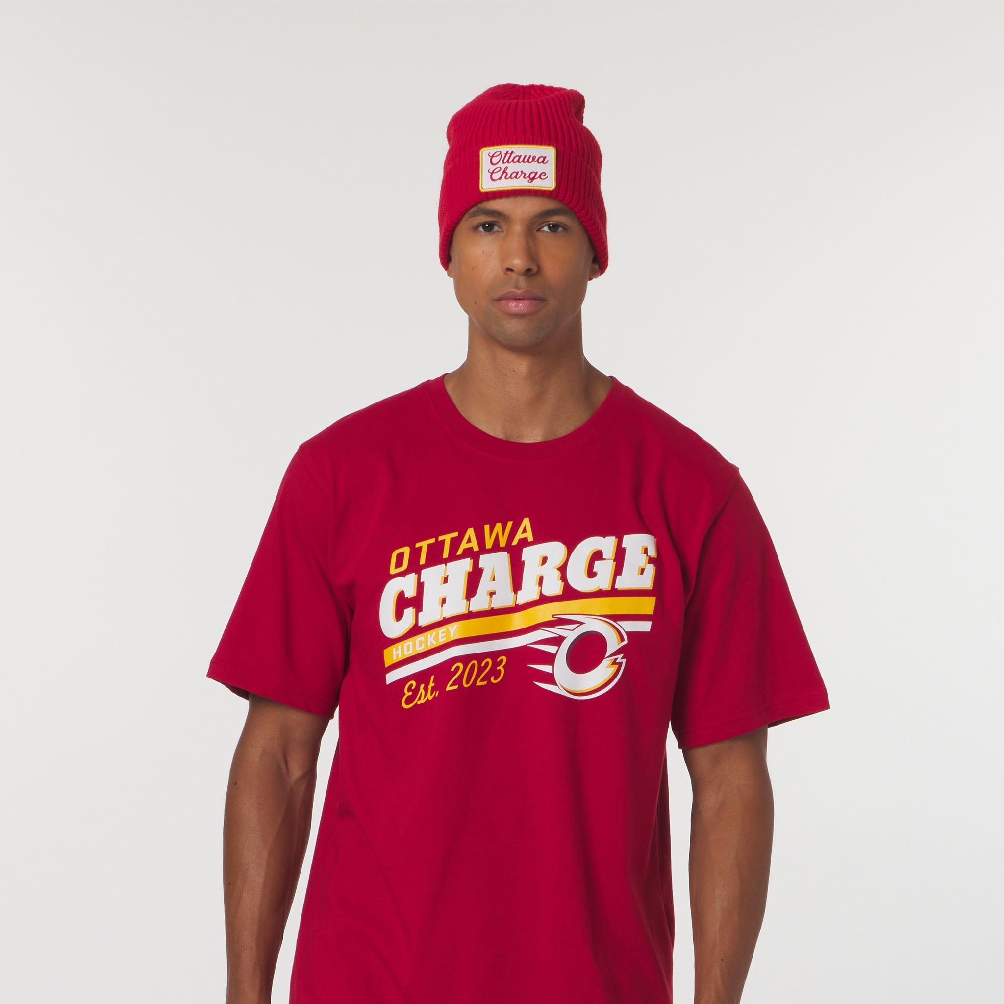 Person wearing a red 'Ottawa Charge' t-shirt and beanie on a white background