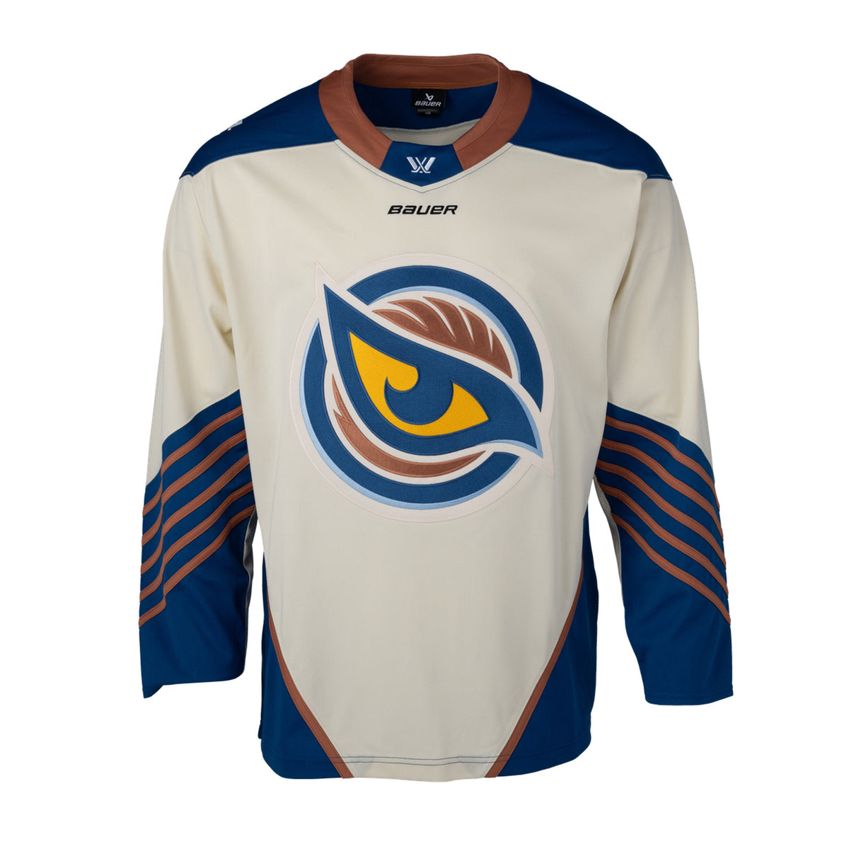 Front of a cream-colored jersey with the Vancouver Goldeneyes logo in the center. The hips have blue color blocking with a tan line on top. The tan collar has a blue color block with the PWHL logo and the Bauer logo is beneath it. The blue shoulder caps have the PWHL logo on the left shoulder. The sleeves are cream and from the elbow down are blue with small tan stripes.