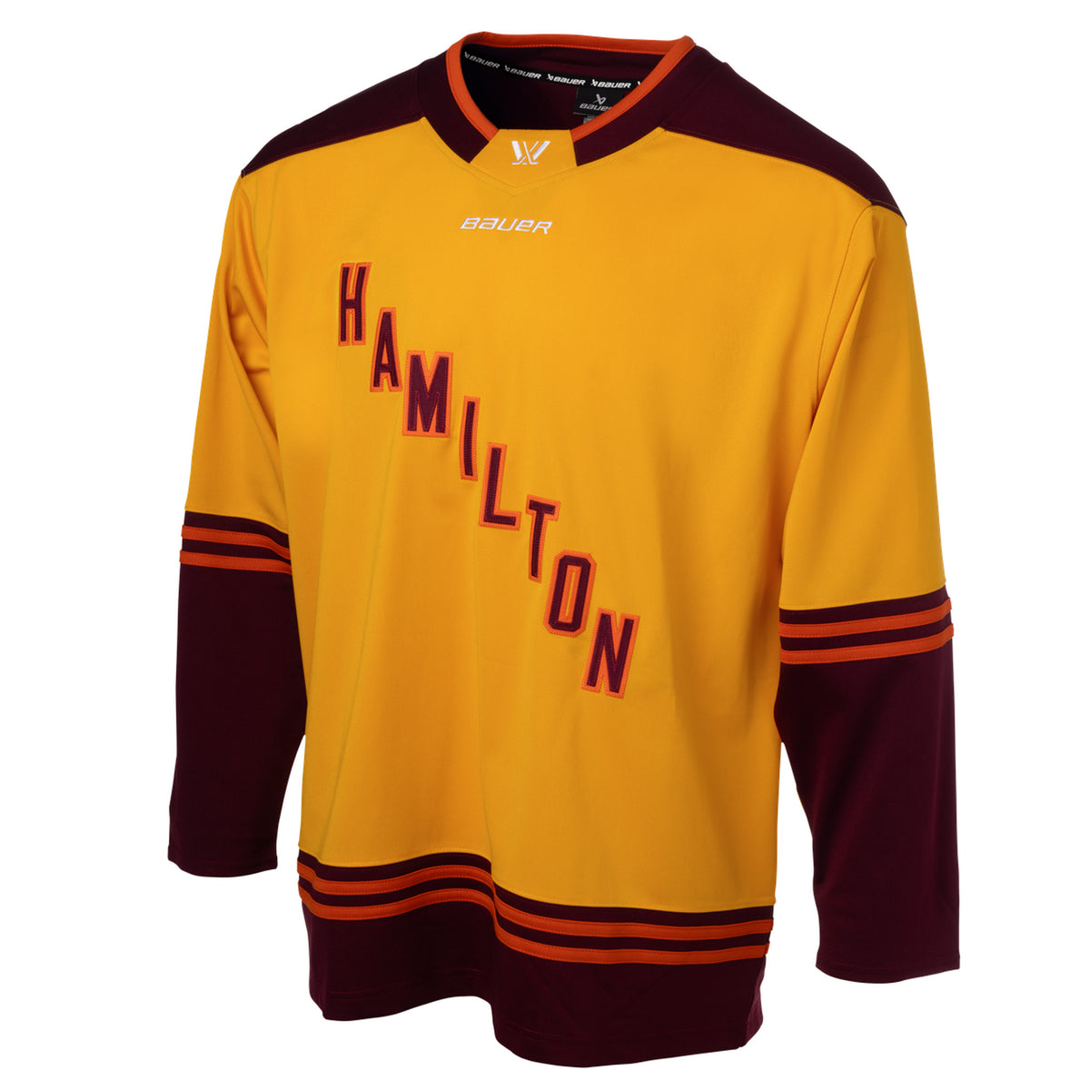 Front of a gold jersey with maroon shoulder caps. Maroon color blocking on the sleeves and bottom hem with orange stipes on top. 'HAMILTON' is in maroon with orange outlining diagonally across the chest. The collar is maroon with orange trim and a gold color block in front showcasing a white PWHL logo with a Bauer logo below it. 