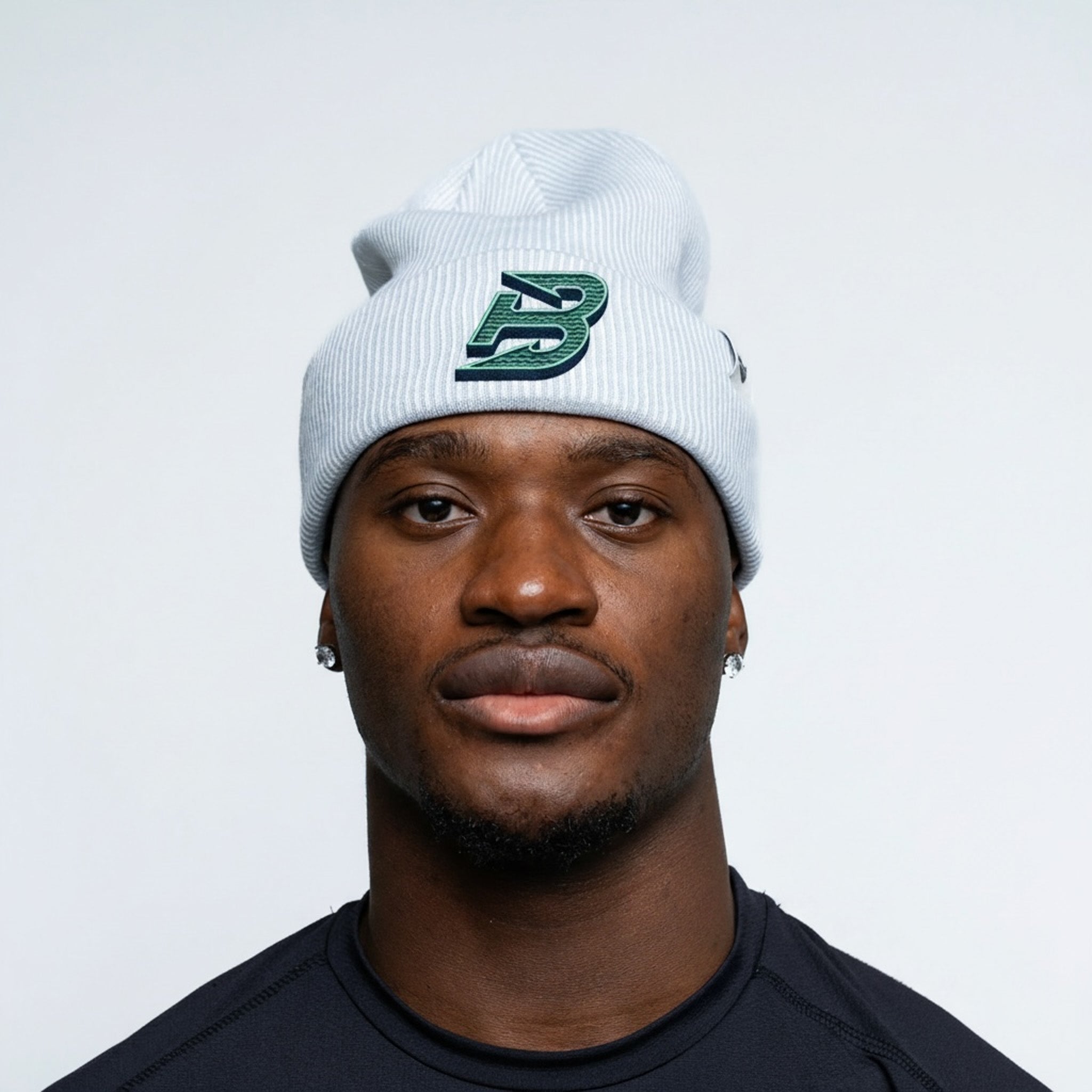 Man wearing a white beanie with a logo on a plain background