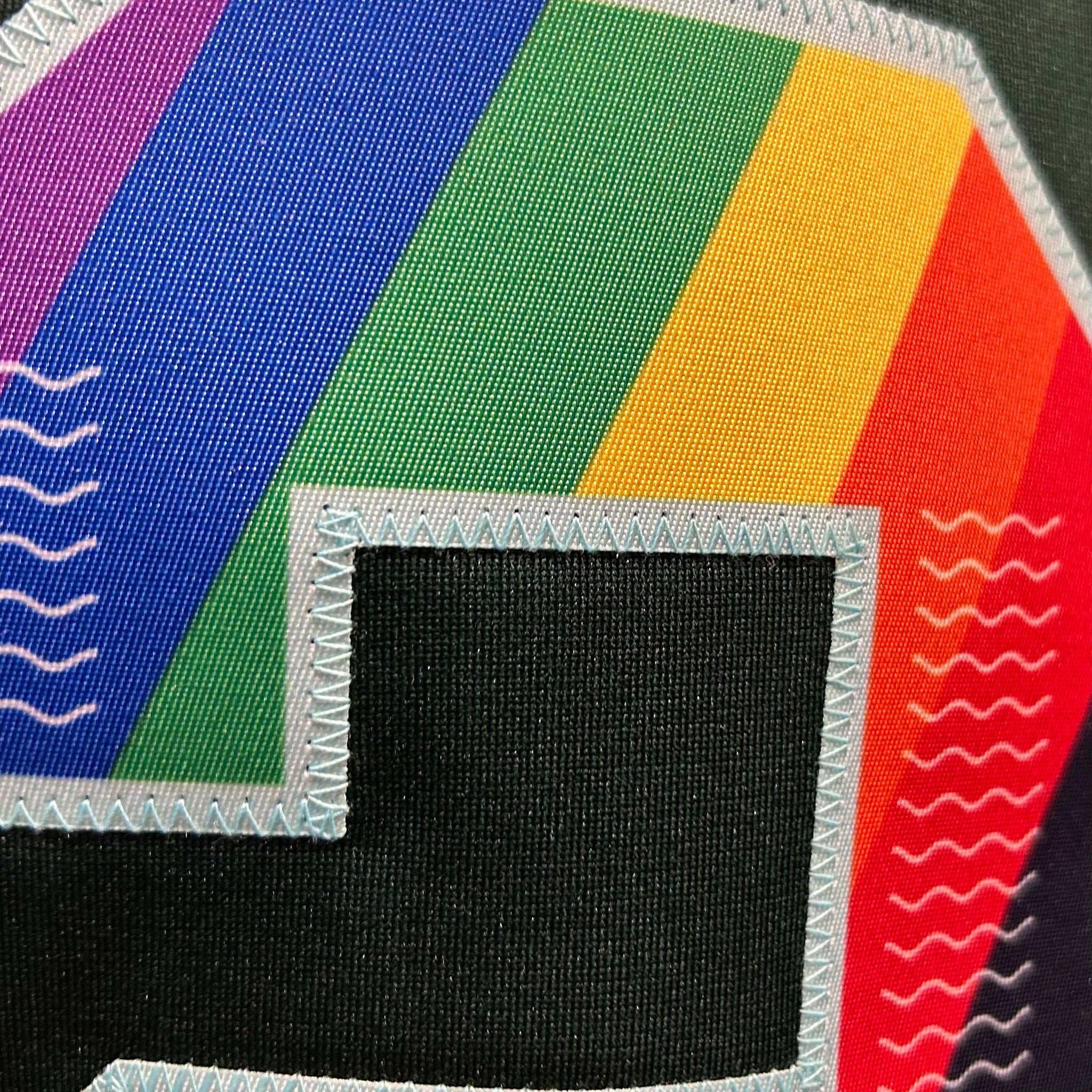 Colorful fabric patch with rainbow pattern and black square