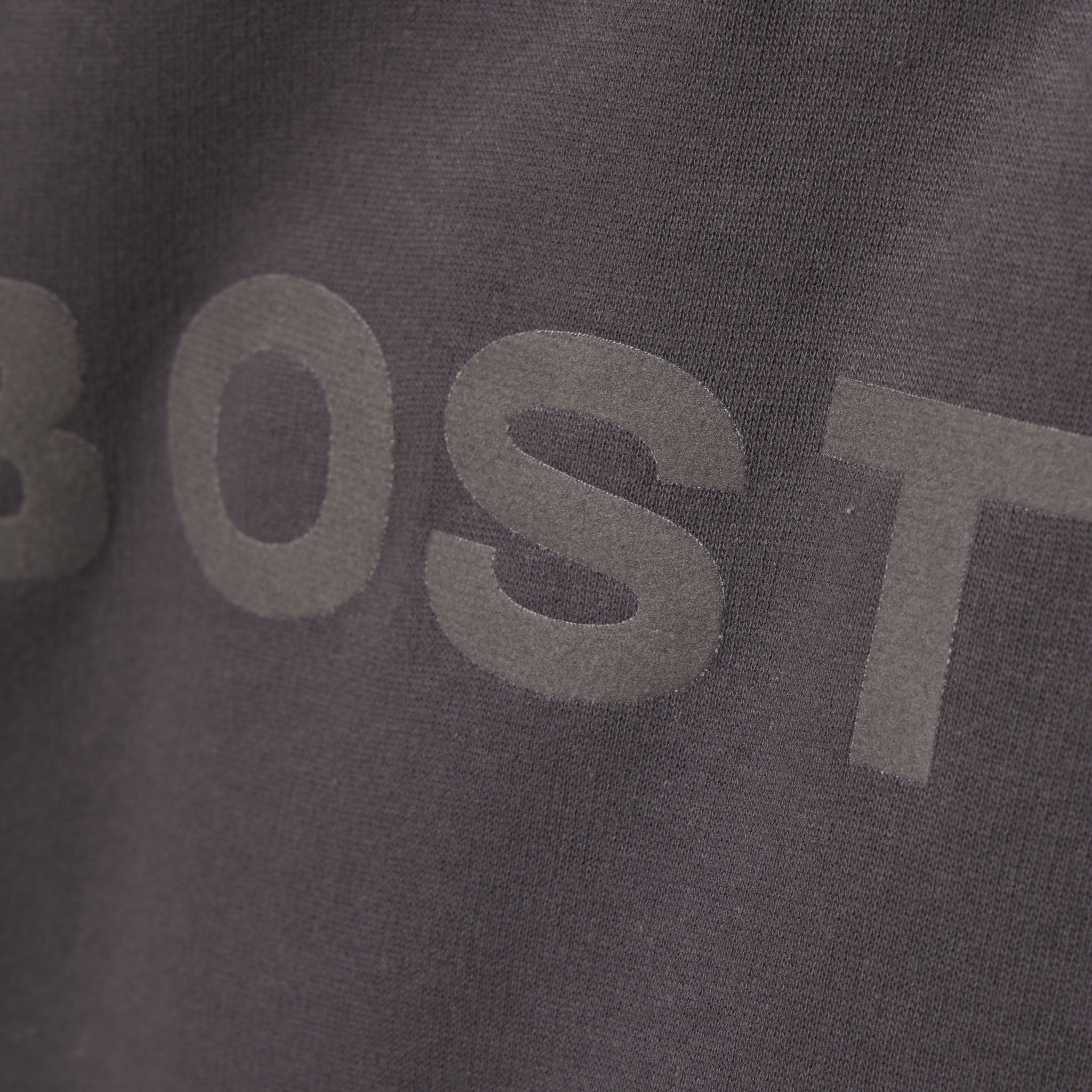 Close-up of a dark gray fabric with 'BOST' printed on it.