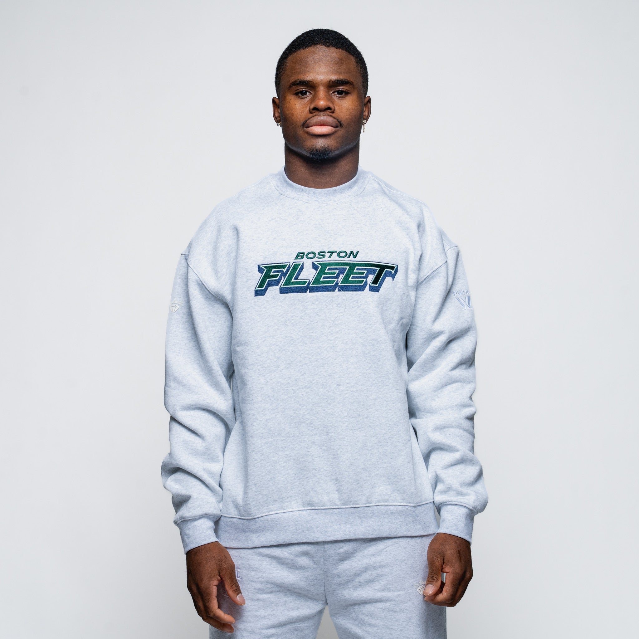 Person wearing a gray sweatshirt with 'Boston Fleet' text on a plain background