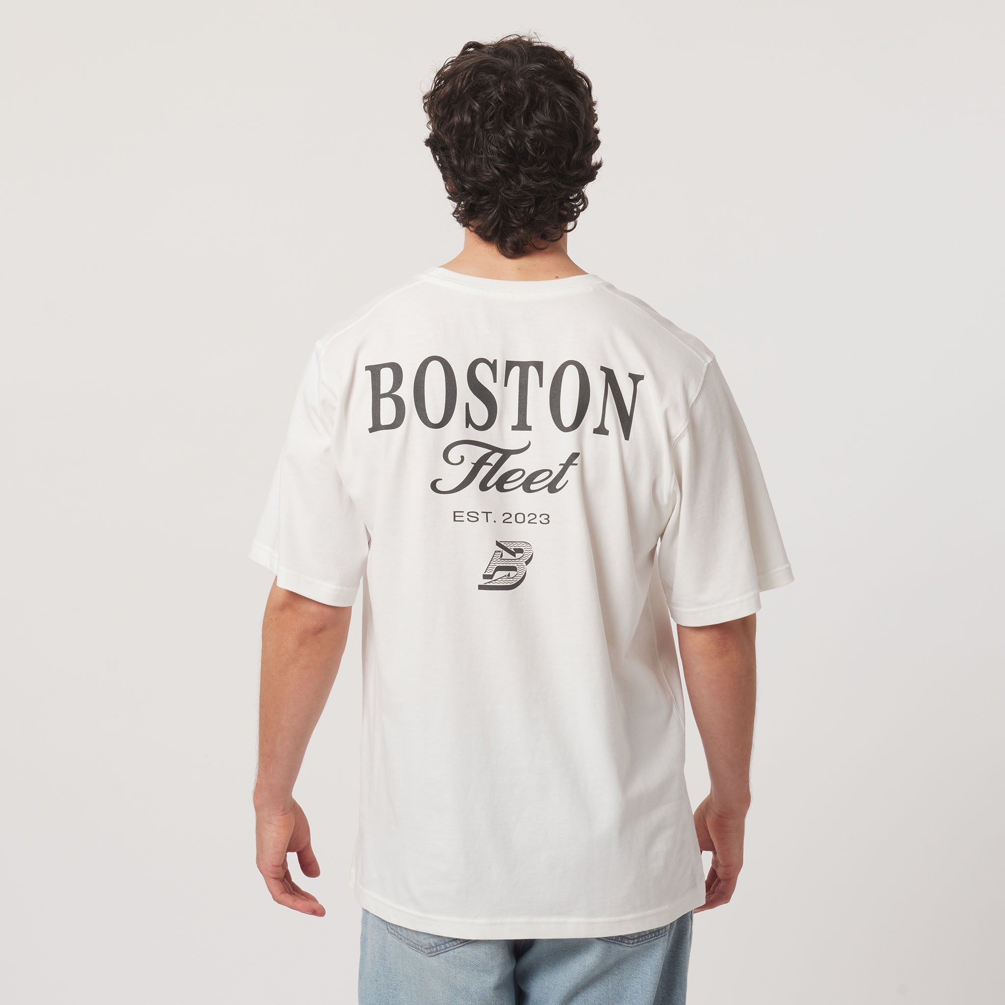 Person wearing a white t-shirt with 'Boston Fleet' text on the back, standing against a plain background