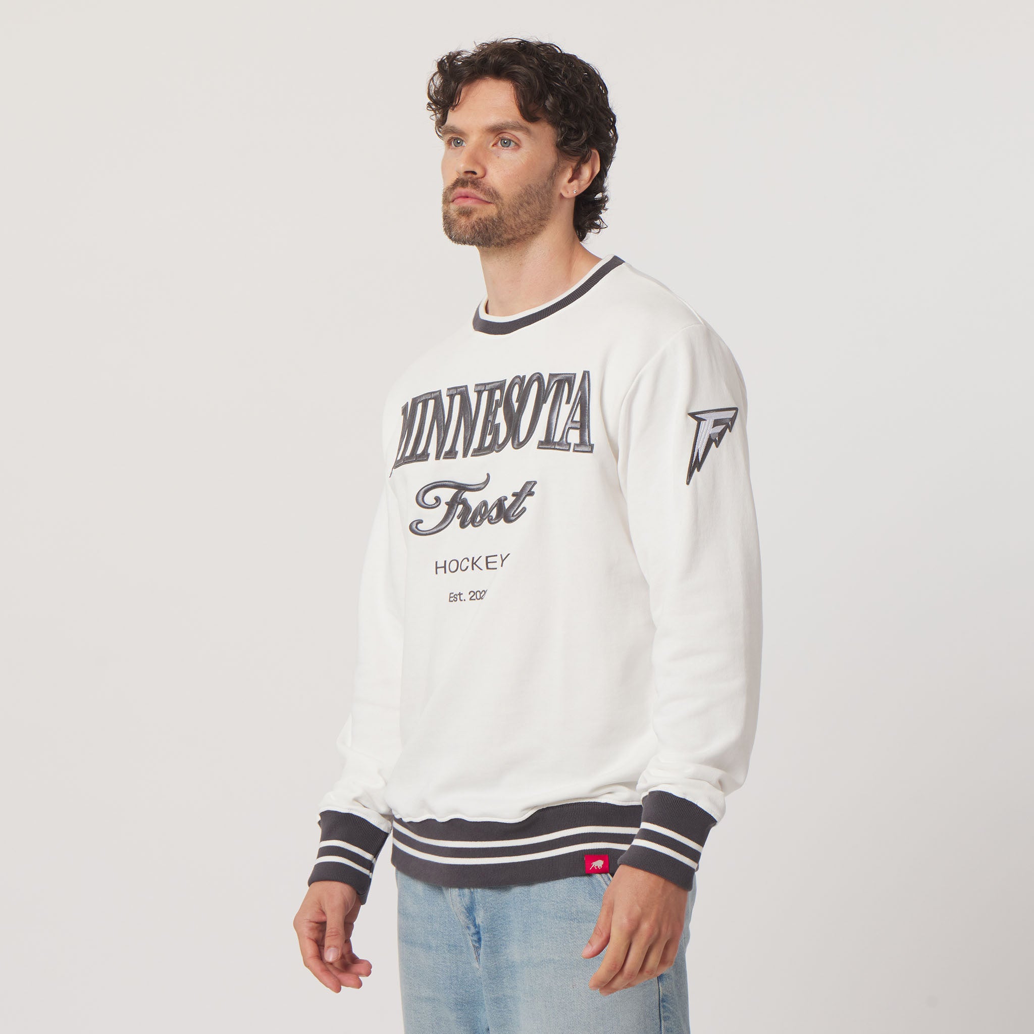 Man wearing a white sweatshirt with 'Minnesota Frost' text on a plain background