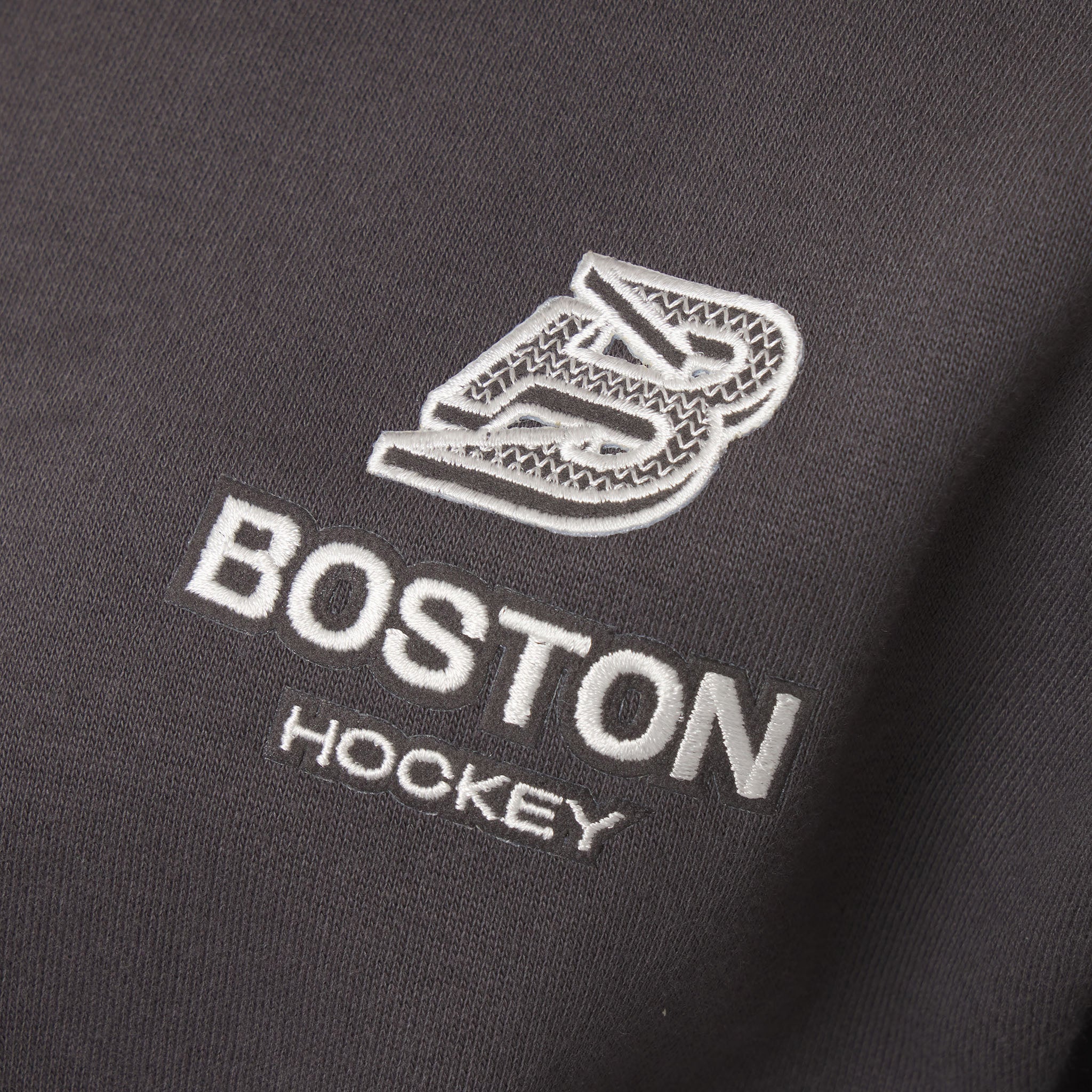 Embroidered logo on a black fabric with 'Boston Hockey' text