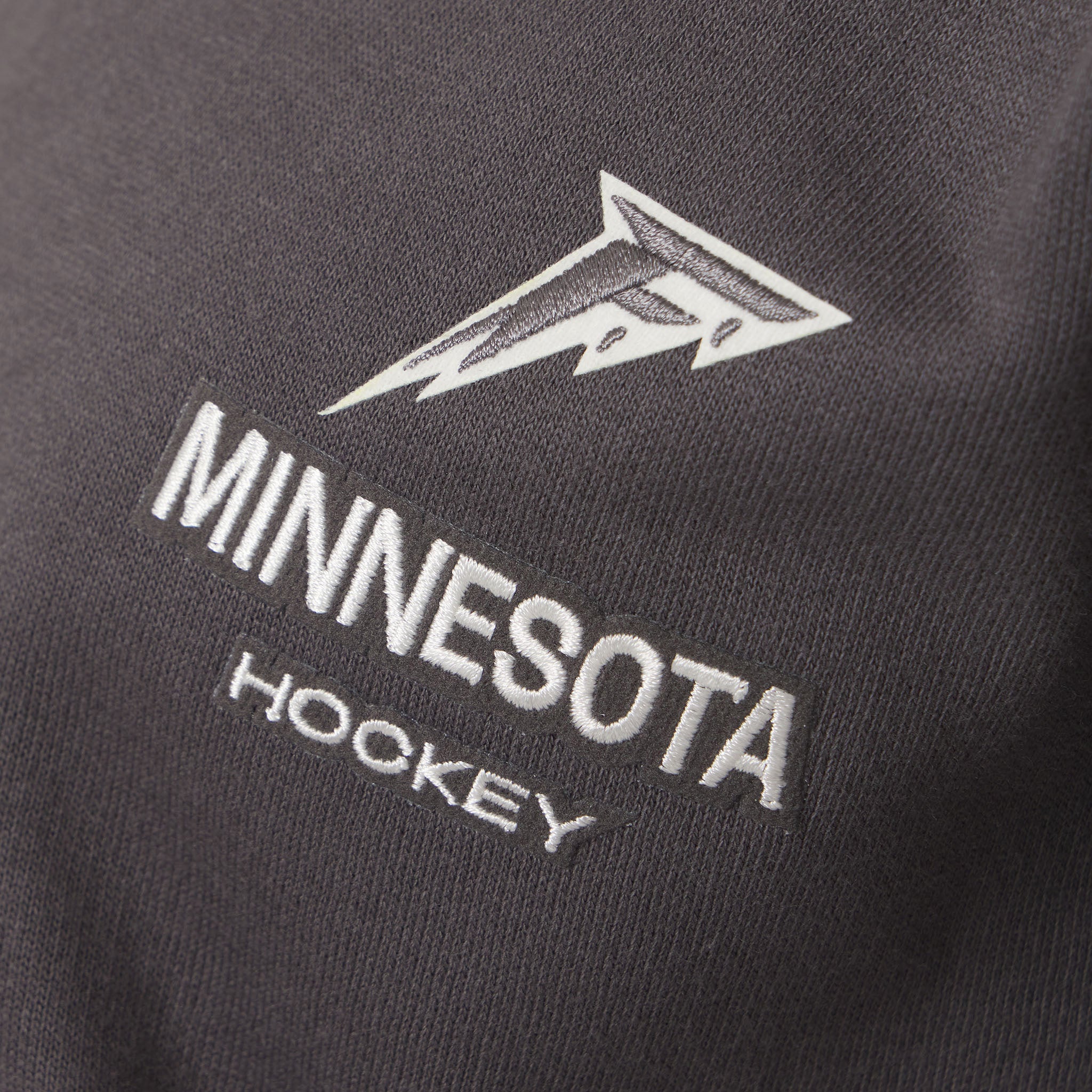 Black sweatshirt with 'Minnesota Hockey' text and logo on a dark background