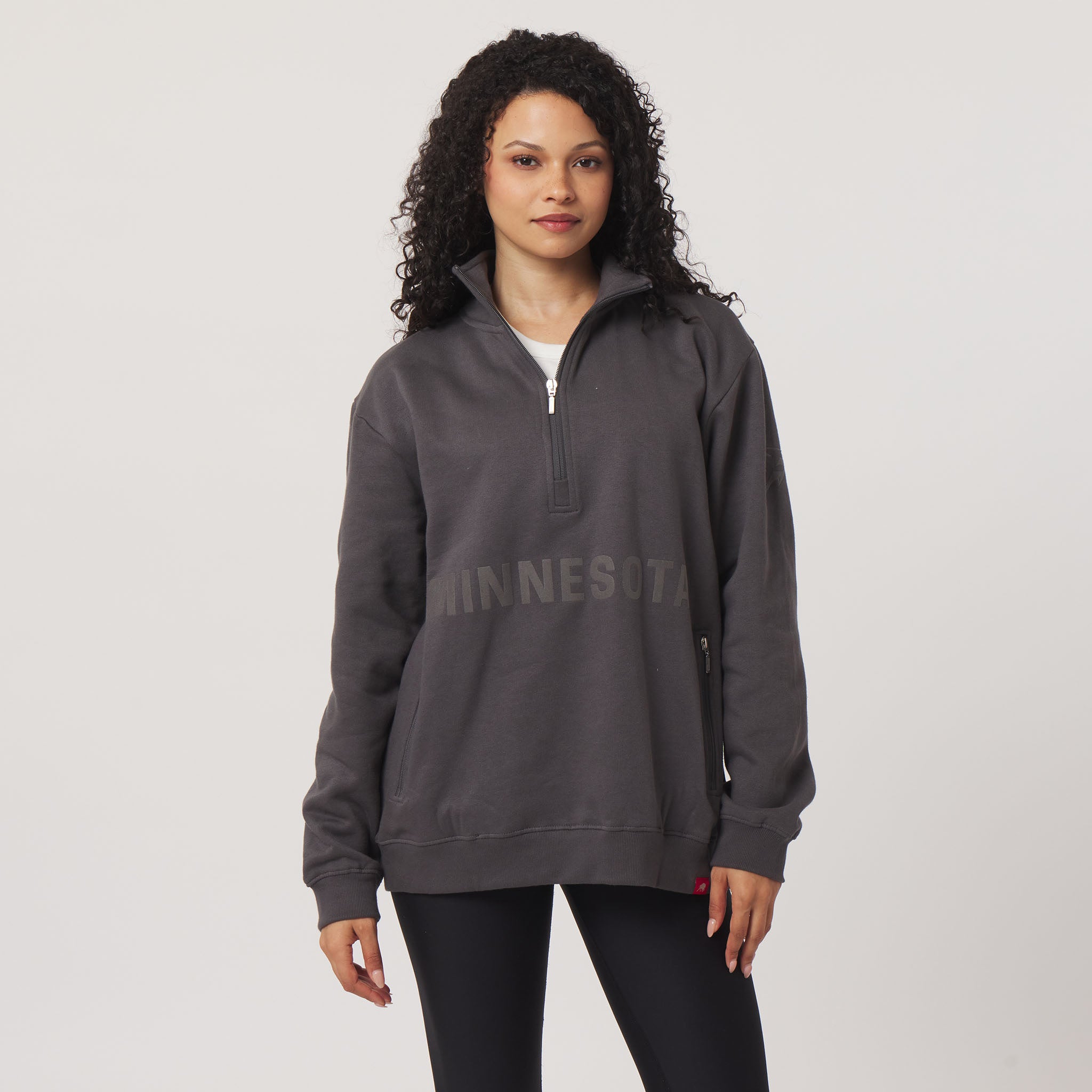 Woman wearing a gray 'Minnesota' pullover on a light gray background