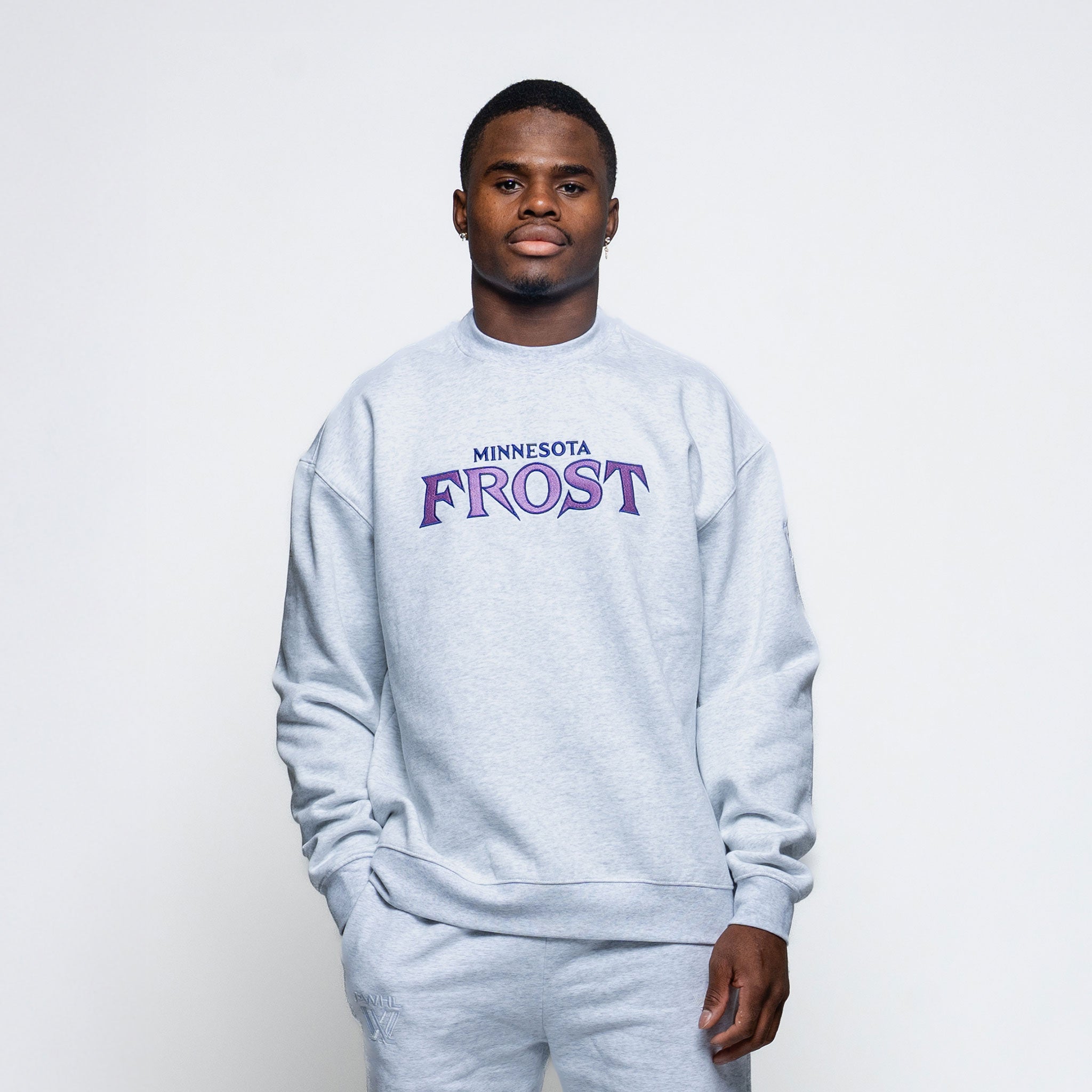 Person wearing a gray sweatshirt with 'Minnesota Frost' text on a white background