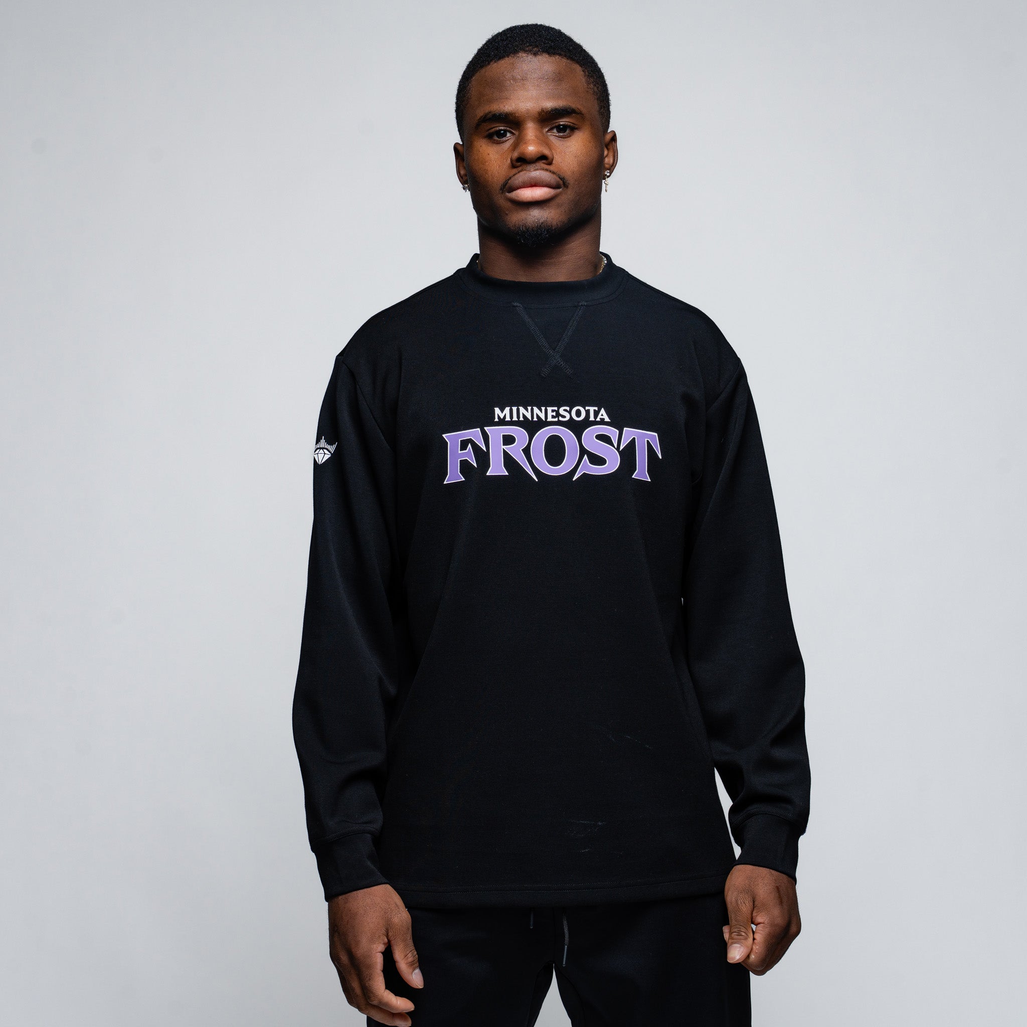 Person wearing a black sweatshirt with 'Minnesota Frost' text on a plain background
