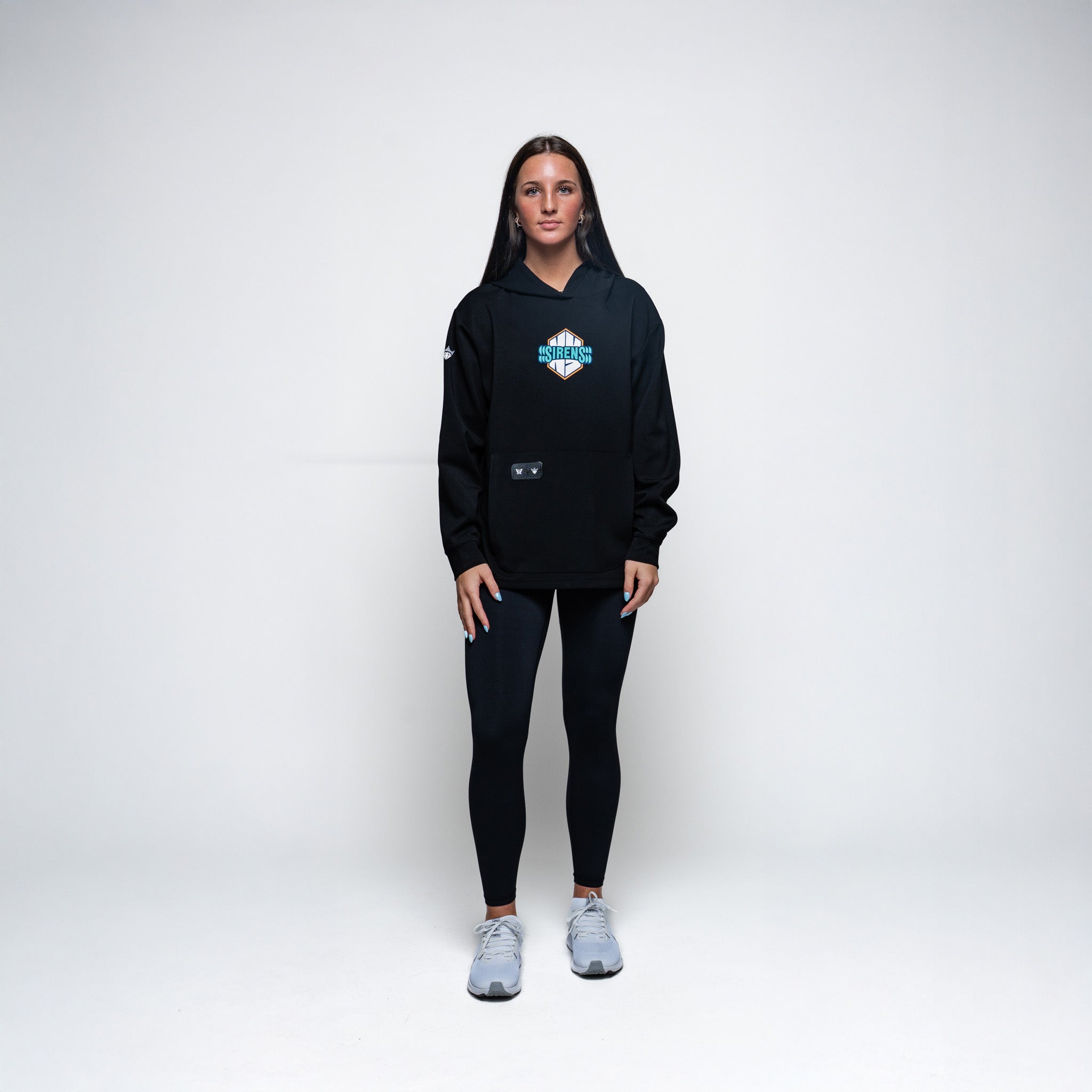 Person wearing a black hoodie and leggings with a logo on a white background