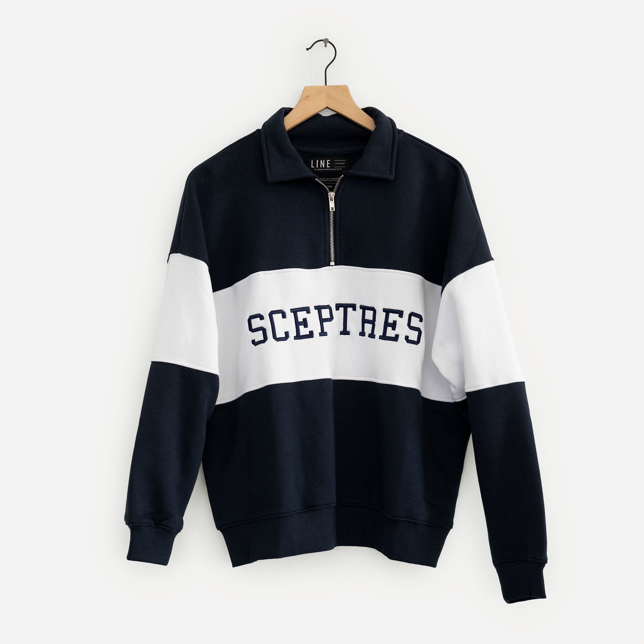 Navy and white striped sweater with 'SCEPTRES' branding on a hanger against a white background