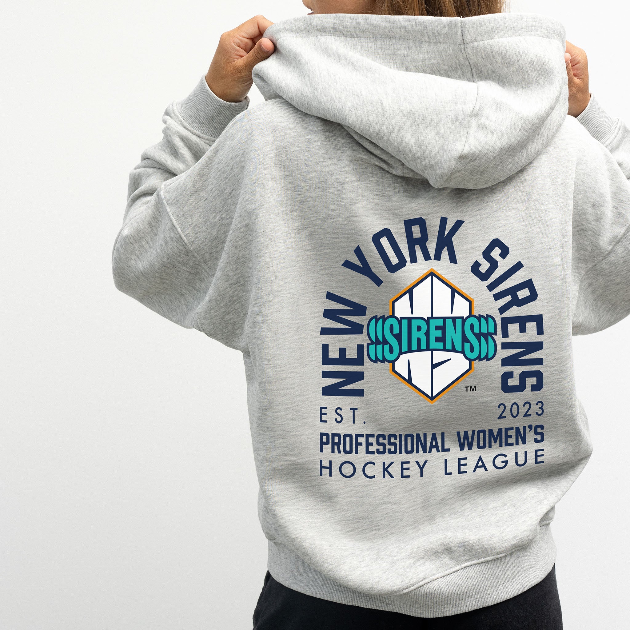 person wearing the New York Sirens grey zip-up hoodie with a graphic design on the back