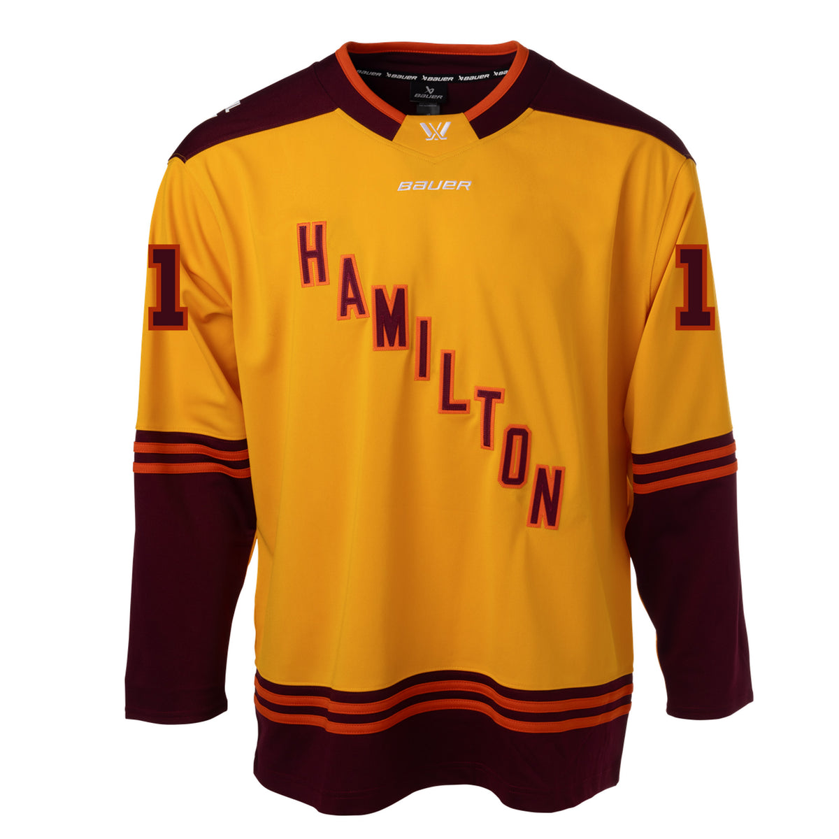 Front of a gold jersey with maroon shoulder caps. Maroon color blocking on the sleeves and bottom hem with orange stipes on top. 'HAMILTON' is in maroon with orange outlining diagonally across the chest with '11' on each sleeve. The collar is maroon with orange trim and a gold color block in front showcasing a white PWHL logo with a Bauer logo below it. 