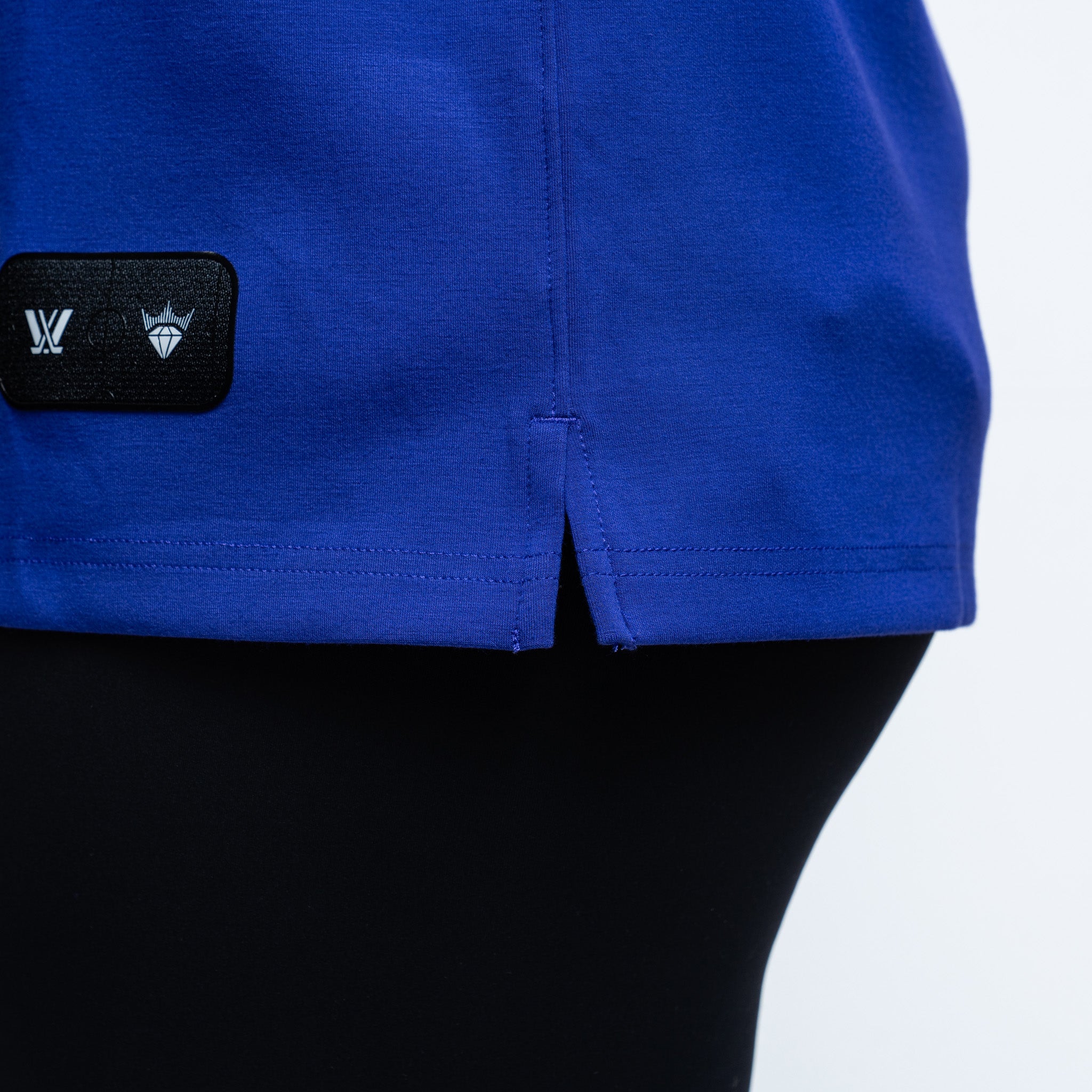 purple sweater with a black patch featuring logos  and a side bottom slit on a white background