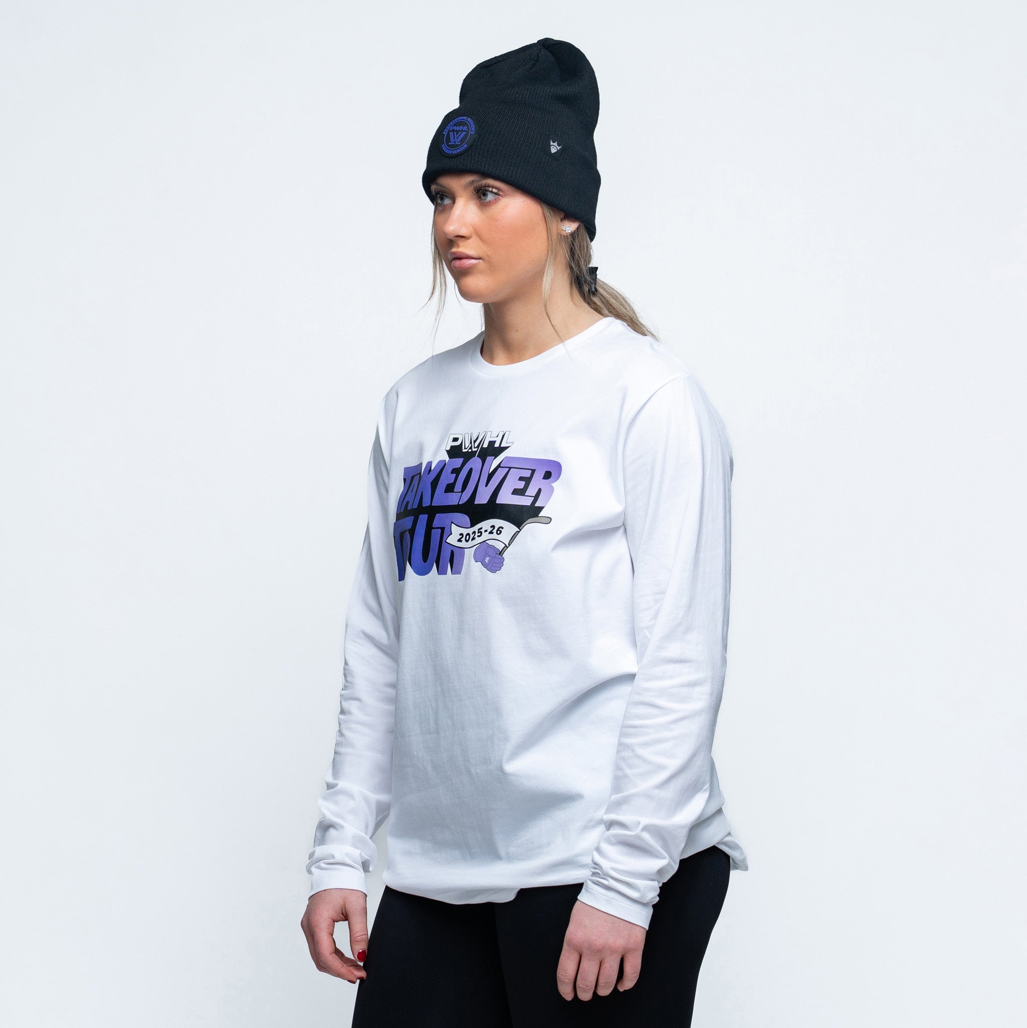Person wearing a white long-sleeve shirt with a logo and text, black beanie, on a light gray background
