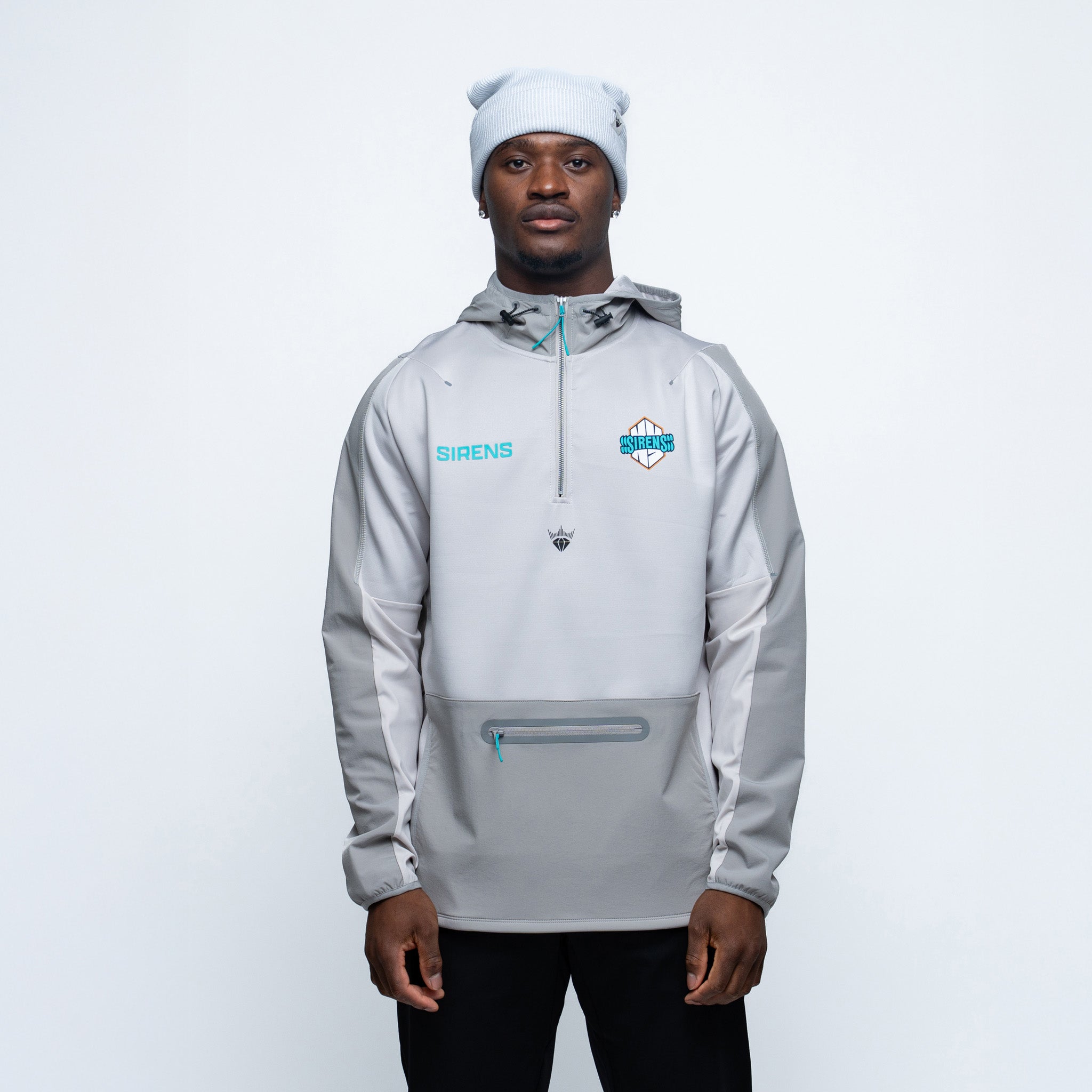 Person wearing a gray jacket with branding on a white background