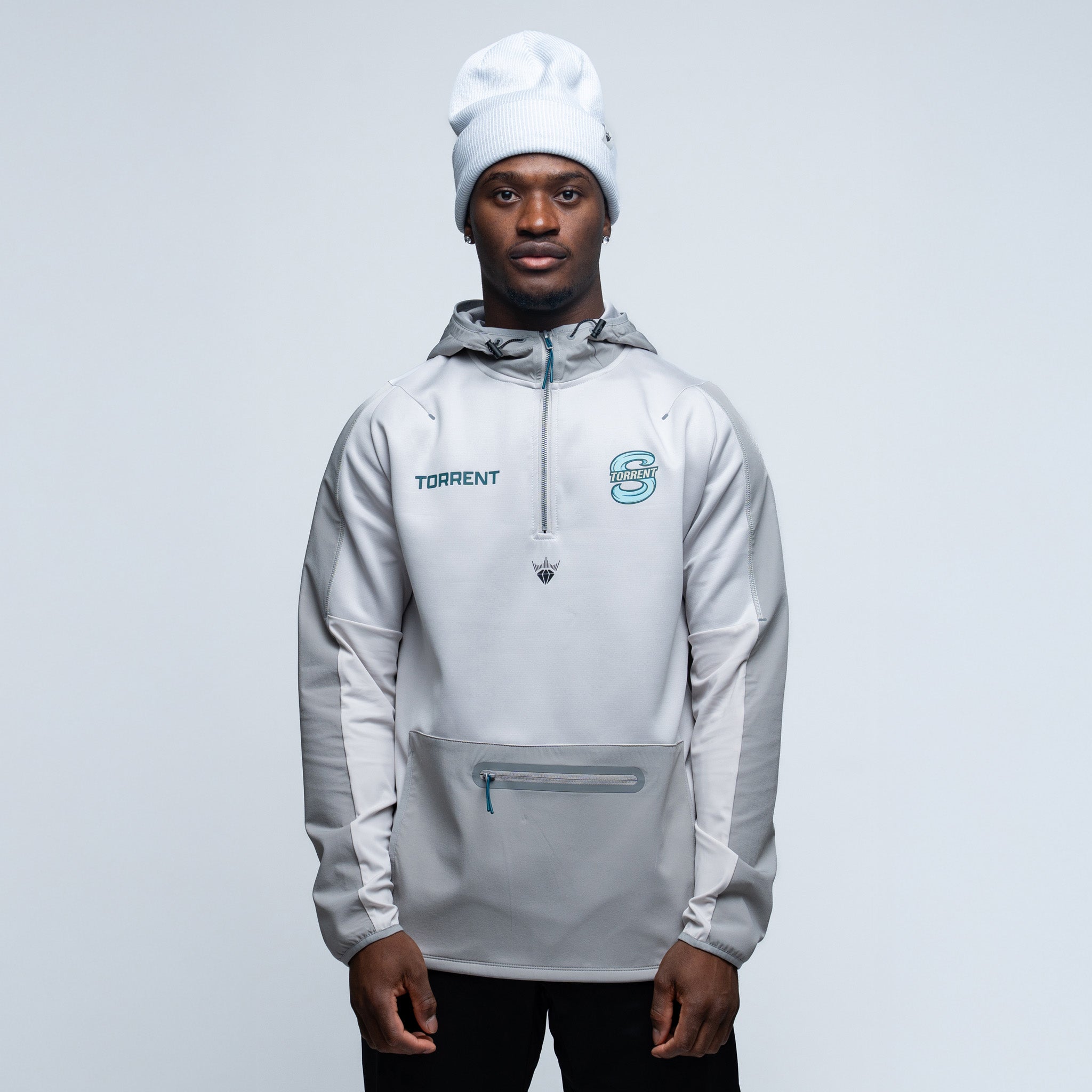 Person wearing a light gray jacket with brand logos on a plain background