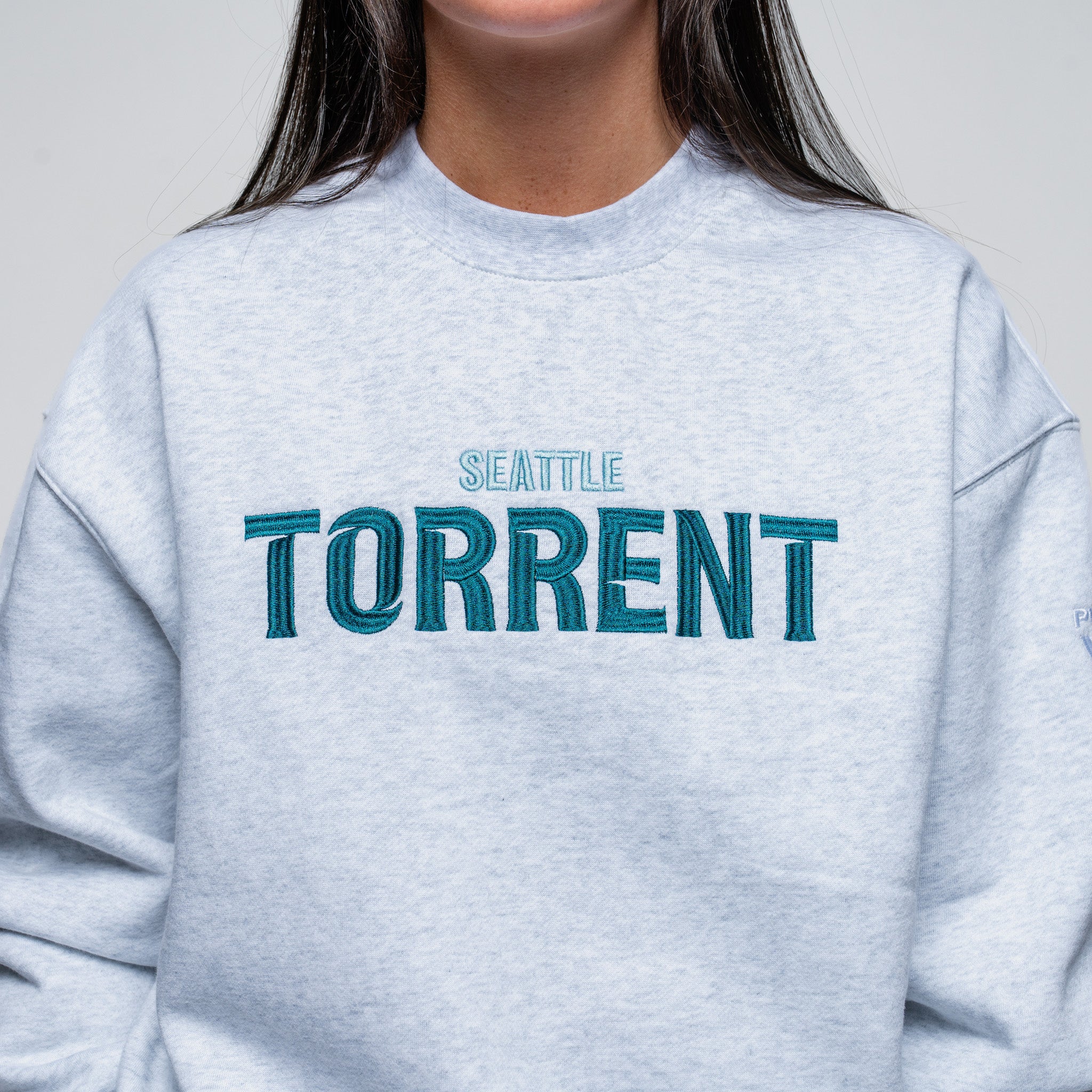 Light blue sweatshirt with 'Seattle Torrent' text on a plain background
