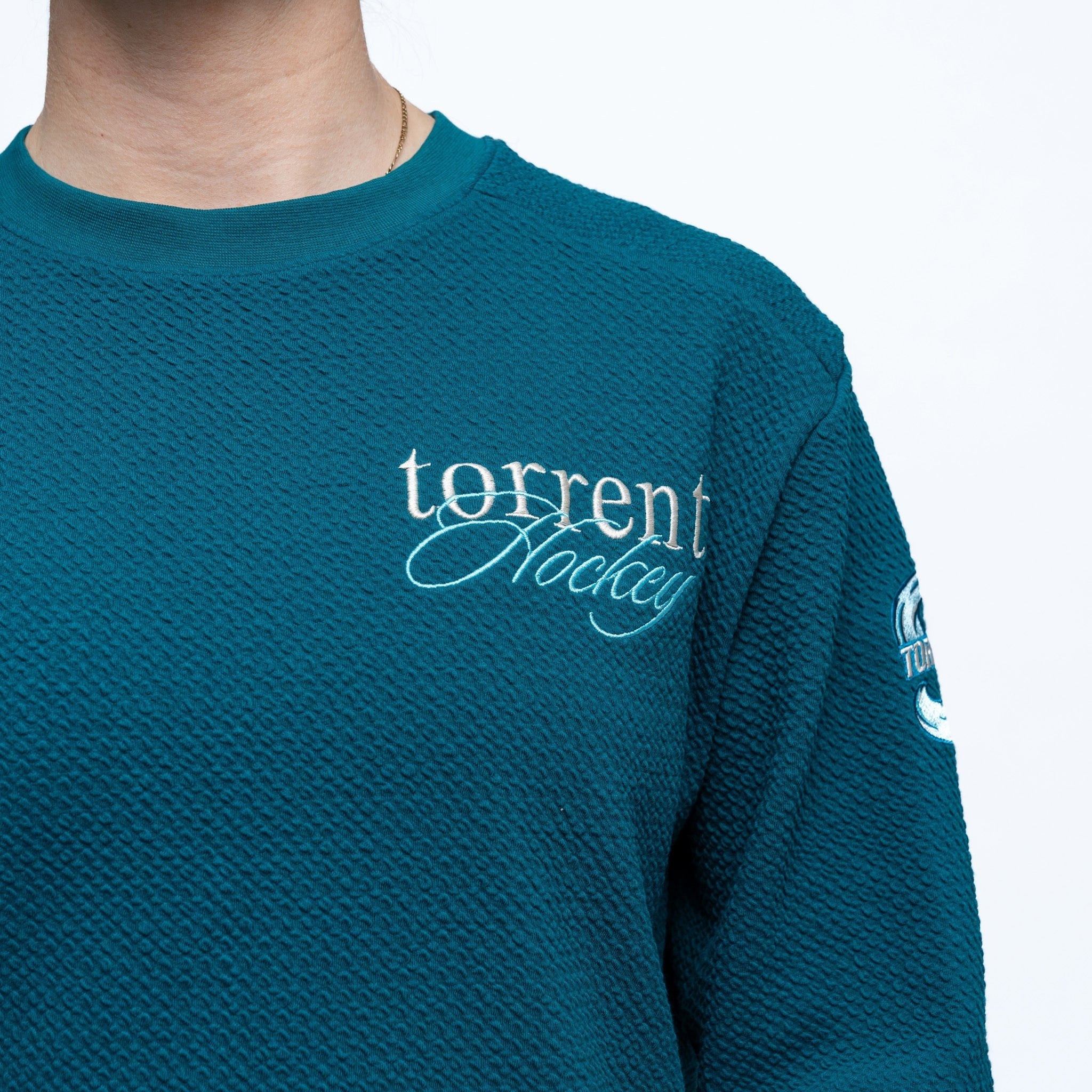 Teal sweatshirt with 'torrent hockey' logo on a white background