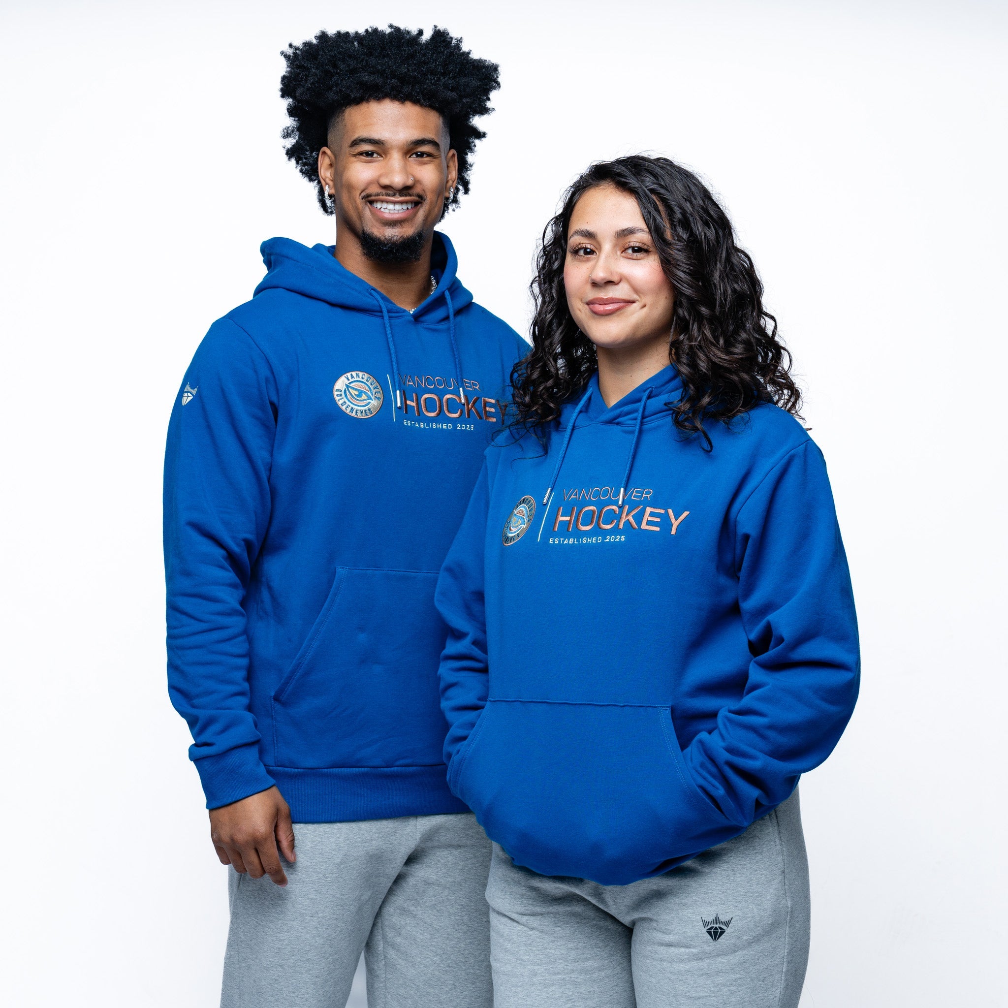 Man and woman wearing the blue Adult Vancouver Goldeneyes Royalty Citymark Cloud Hoodie