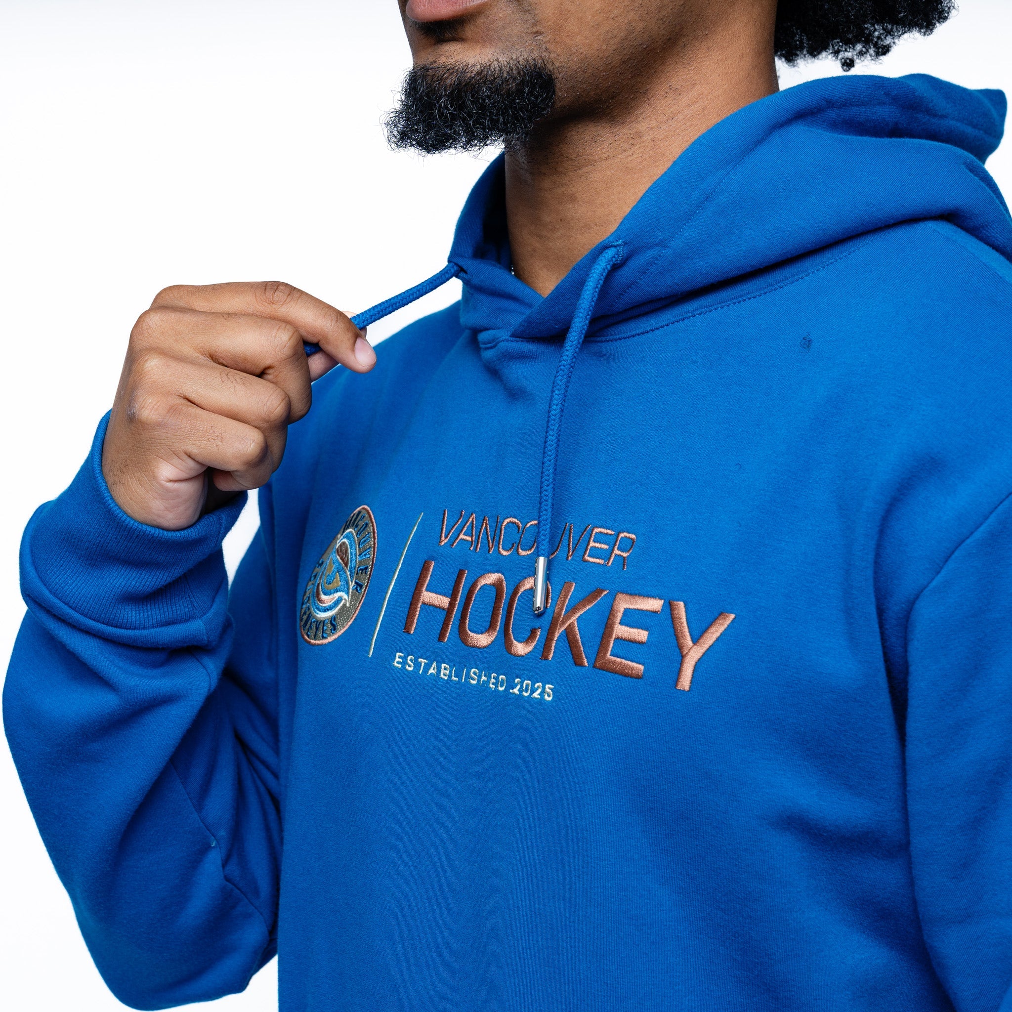 close up of the embroidery on the blue Adult Vancouver Goldeneyes Royalty Citymark Cloud Hoodie side angle