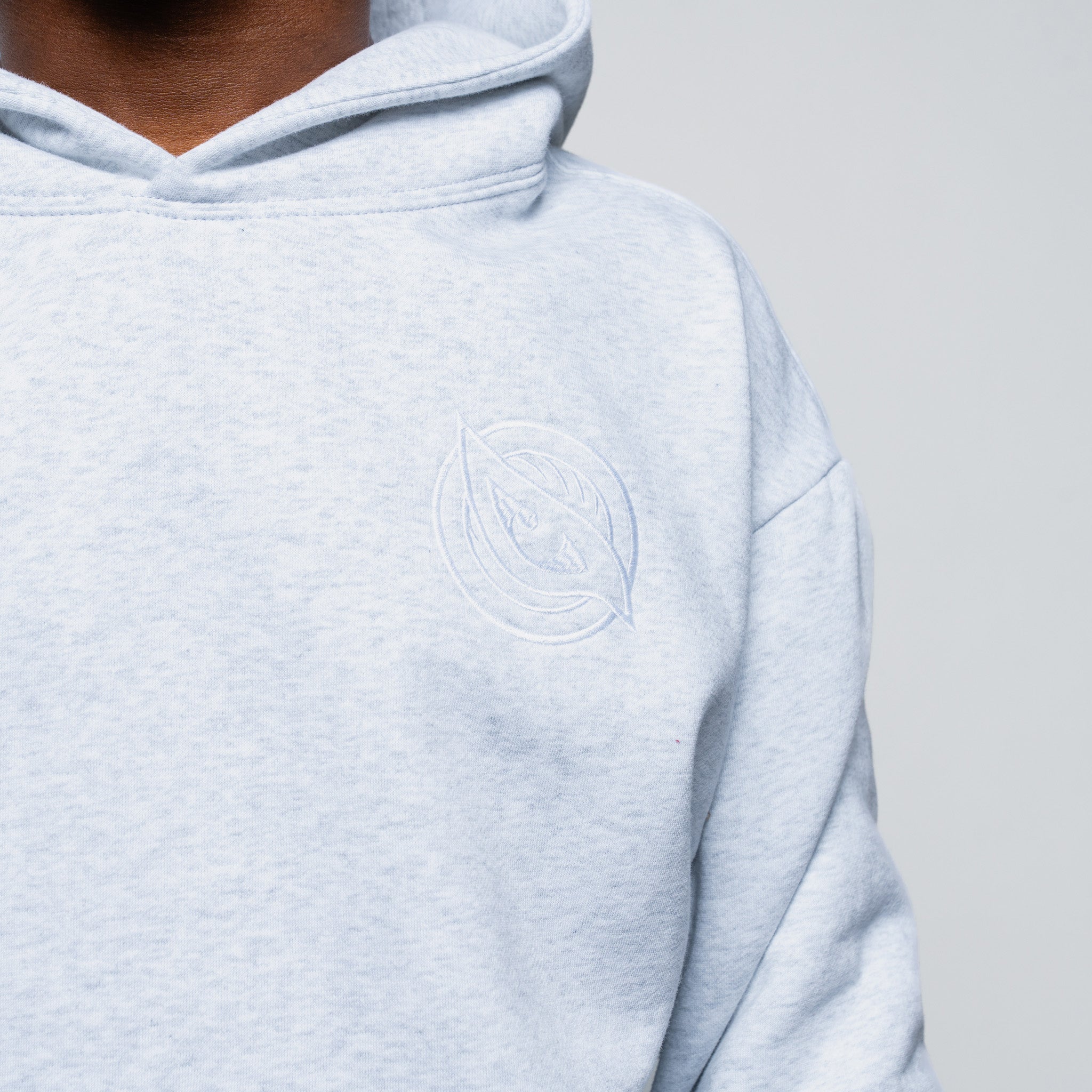 Light blue hoodie with a circular logo on a gray background