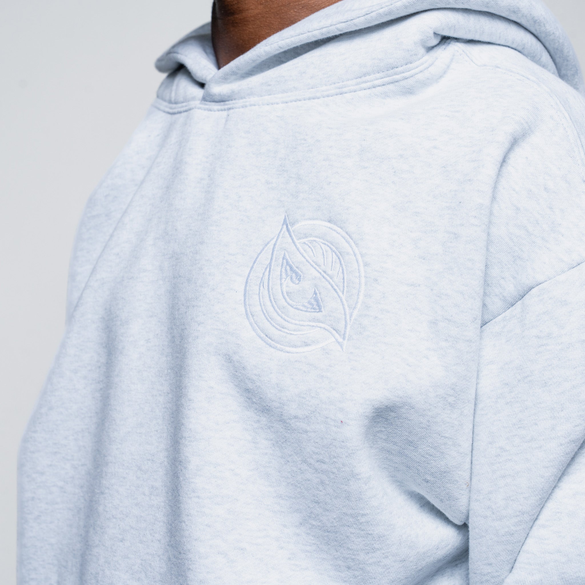 Light blue hoodie with a logo on the chest against a neutral background